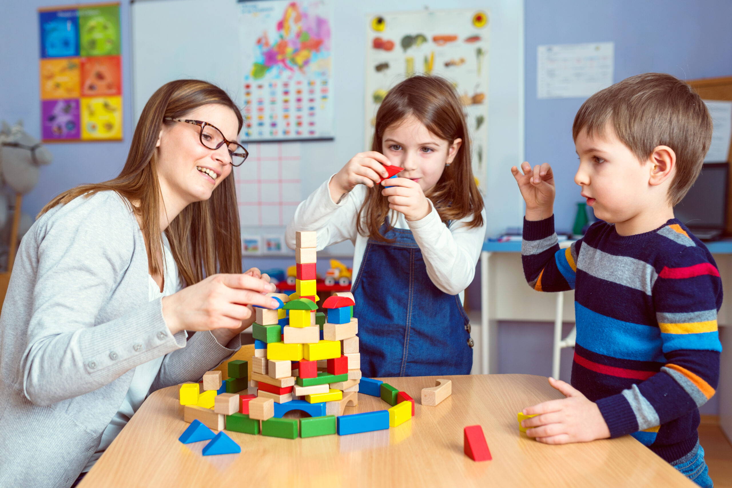 Teacher,And,Kids,Playing,Together,With,Colorful,Toy,Building,Blocks Kids learning at St. Stephen's Day Care